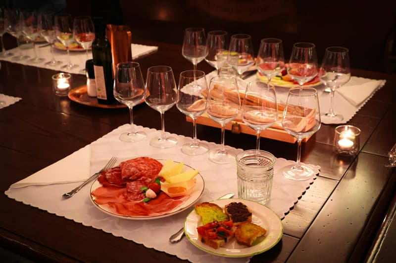 Charcuterie, pain et verres de vin sur une table de bar à vins à la lueur des bougies