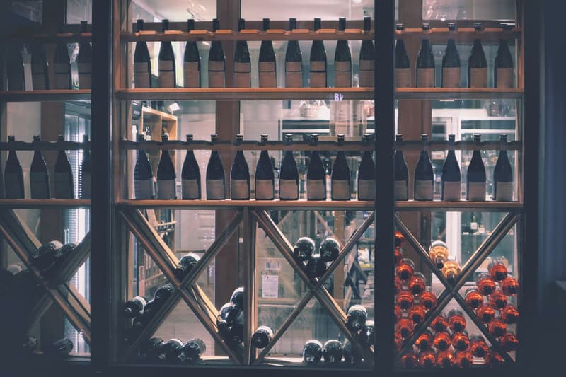 Botellas de vino alineadas en estanterías de madera dentro de una tienda