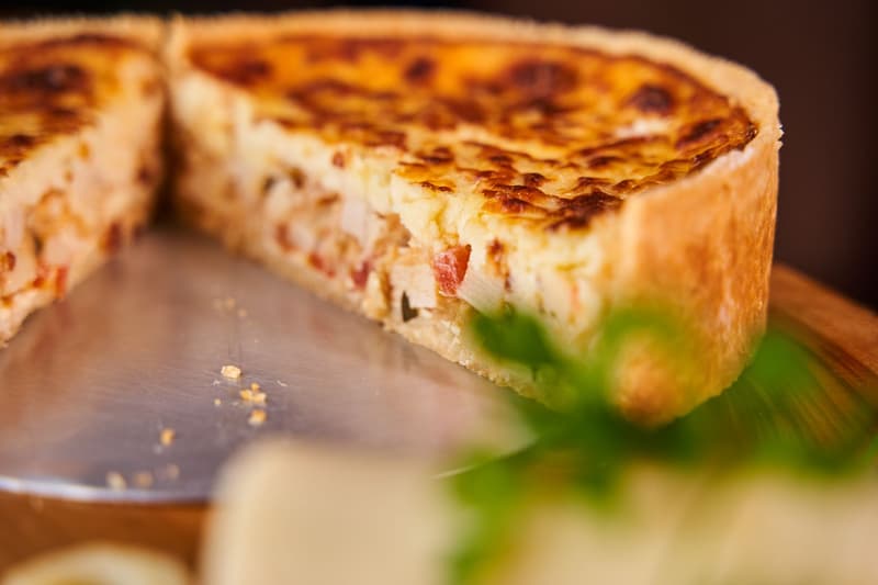Tarta salada de corteza dorada cortada, con el relleno cuajado a la vista