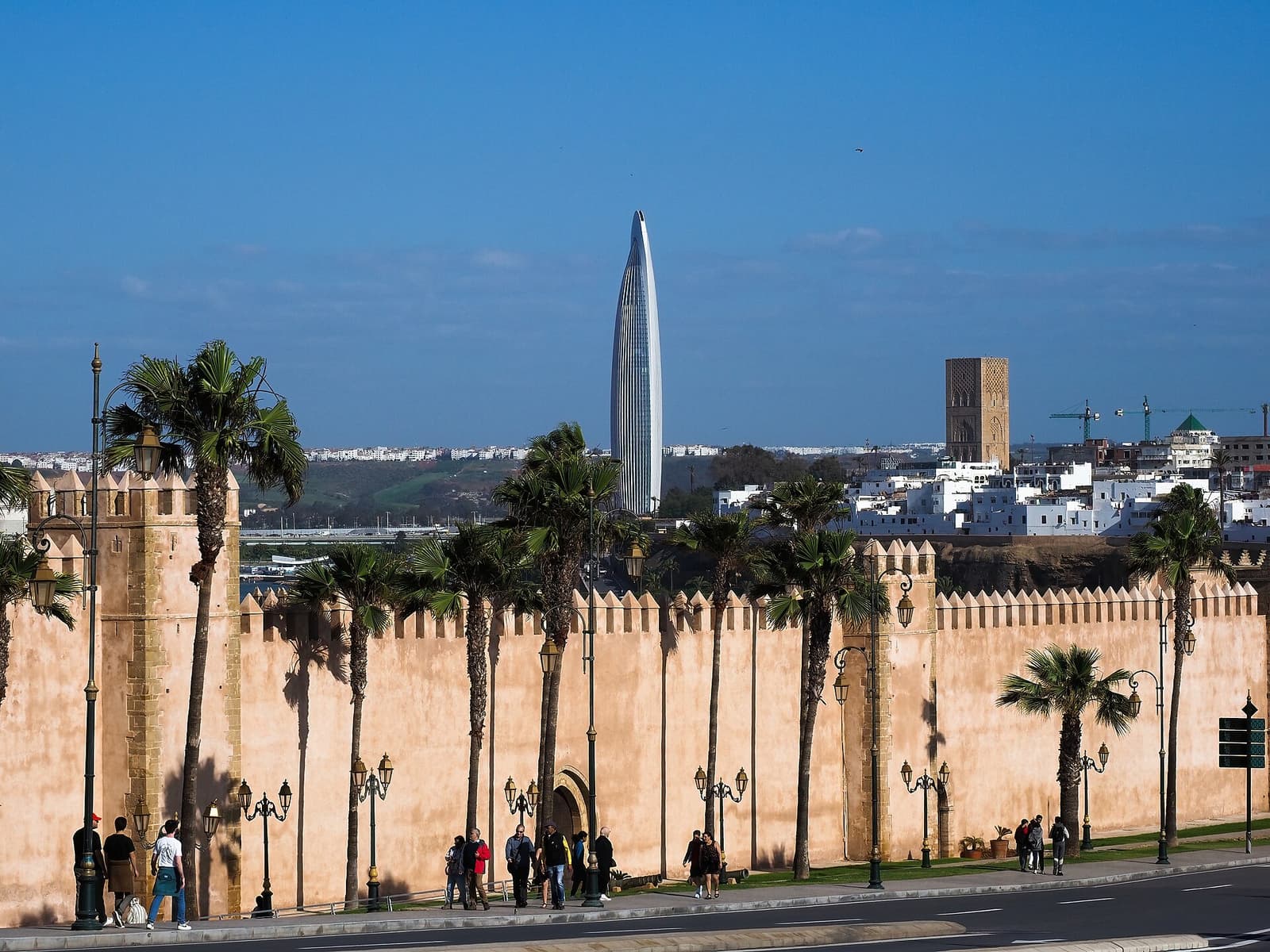 Der Mohammed-VI-Turm ragt hinter den Mauern der Kasbah der Udayas und Palmen auf