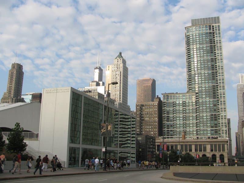 Die weiße Glasfassade des Harris Theater an der Randolph Street, dahinter Hochhäuser von Chicago