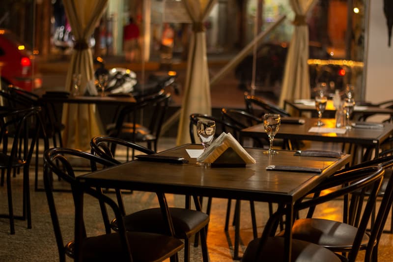 Lege, gedekte tafels in een schemerig verlichte restauranteetzaal 's nachts