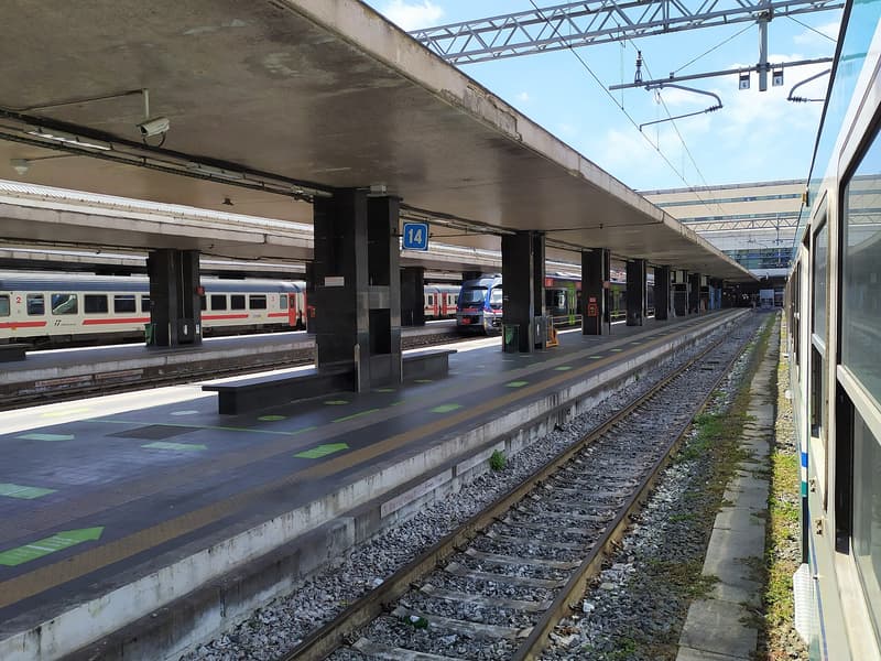 Quai vide sous l'auvent de la gare de Roma Termini, avec des trains à l'arrêt de chaque côté