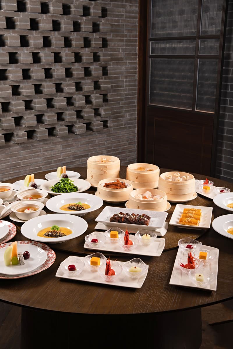 Ronde tafel met dim sum-stoommandjes, soepen en kleine Chinese gerechten