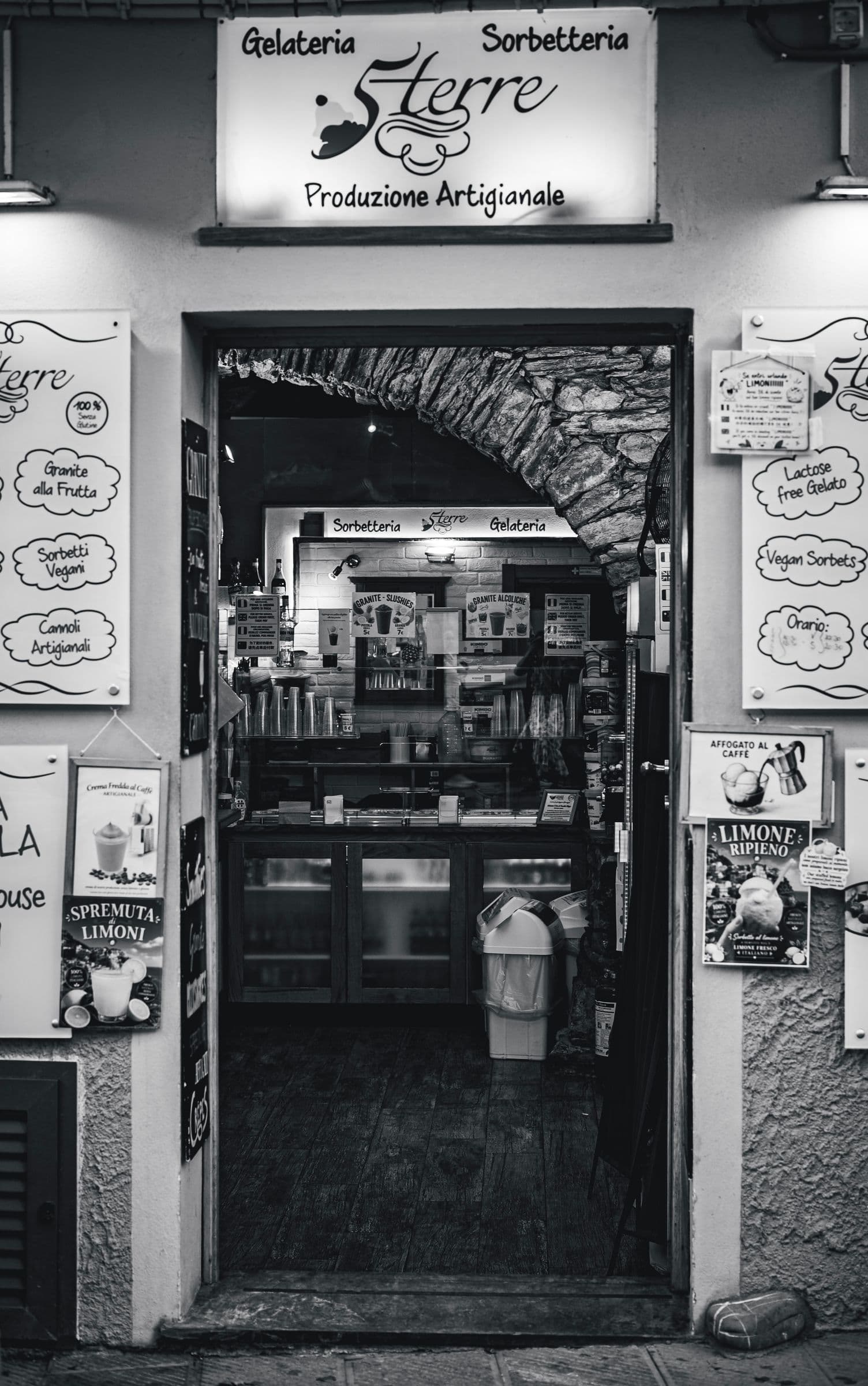 Photo en noir et blanc d'une glacerie avec des panneaux de menu écrits à la main