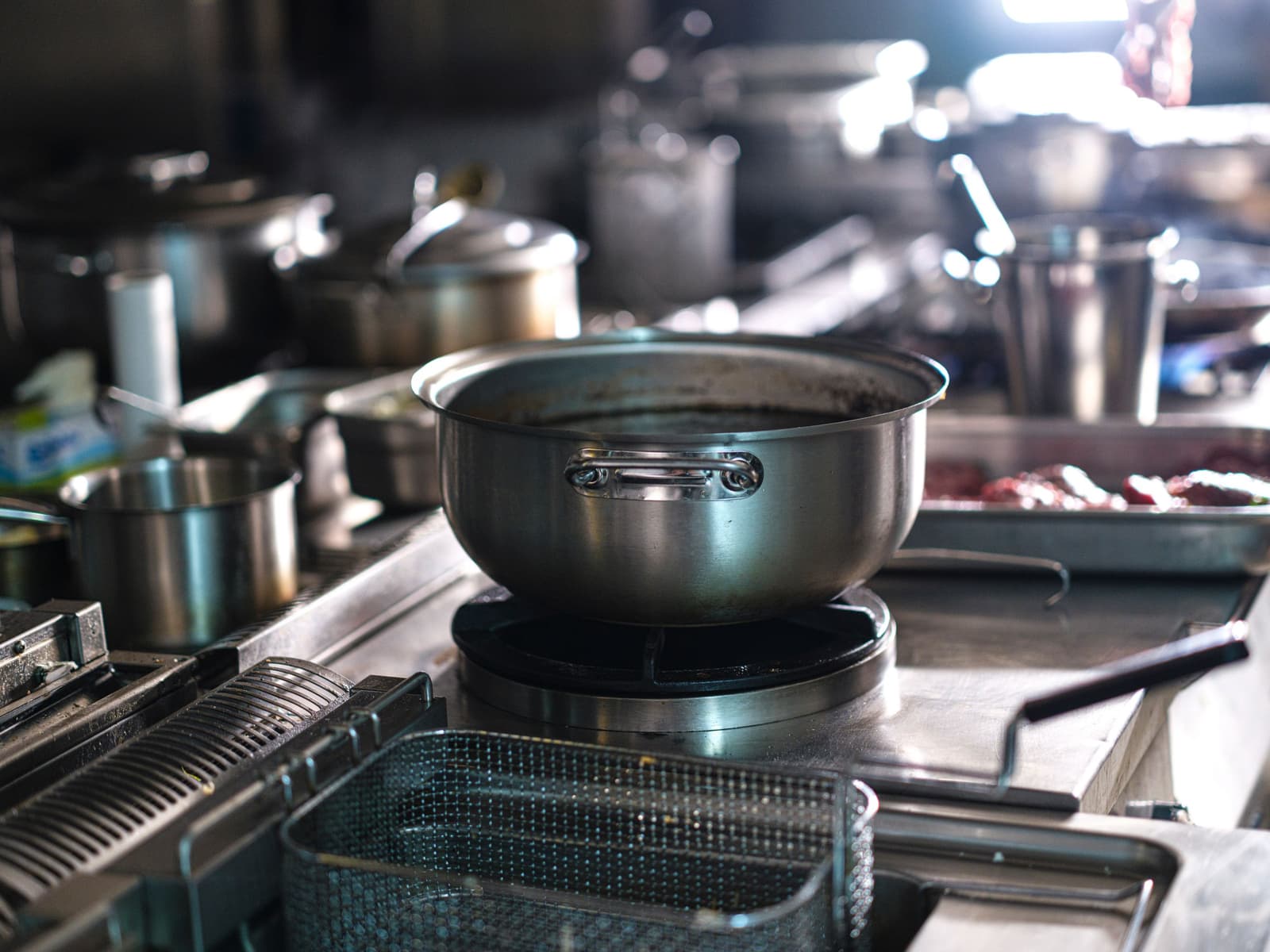 Grande pentola d'acciaio su un fornello a gas in una cucina professionale in attività