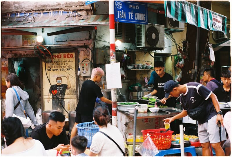 Belebte Straßenküchenstände und Gäste in Hanoi, Vietnam
