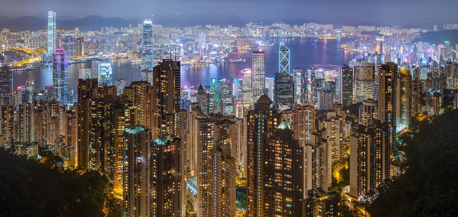 Hongkong Island und Kowloon bei Nacht beleuchtet, zu beiden Seiten von Victoria Harbour, gesehen vom Victoria Peak