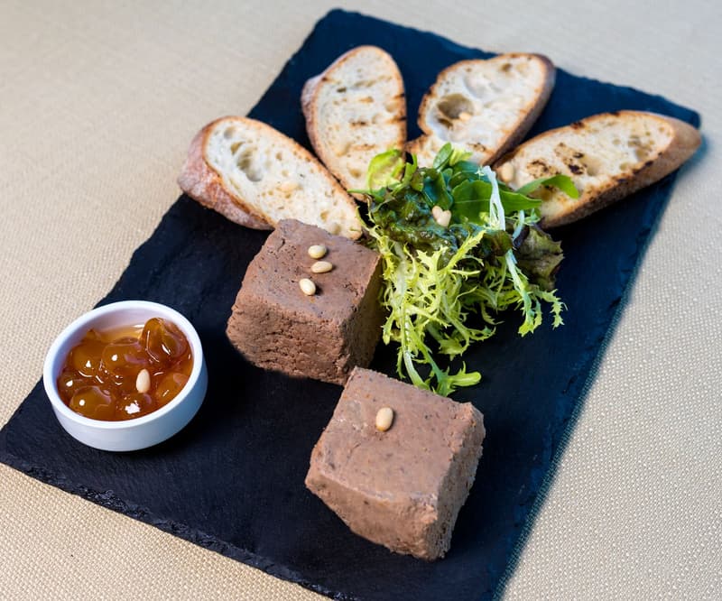 Liver parfait with toasted bread, pine nuts and fruit preserve on slate