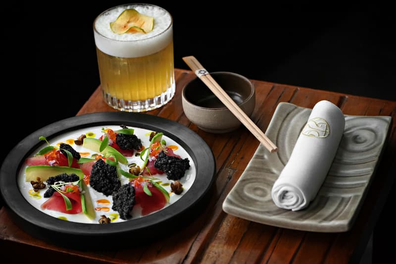 Thunfisch-Kaviar-Fusion-Gericht neben einem Cocktail und Stäbchen