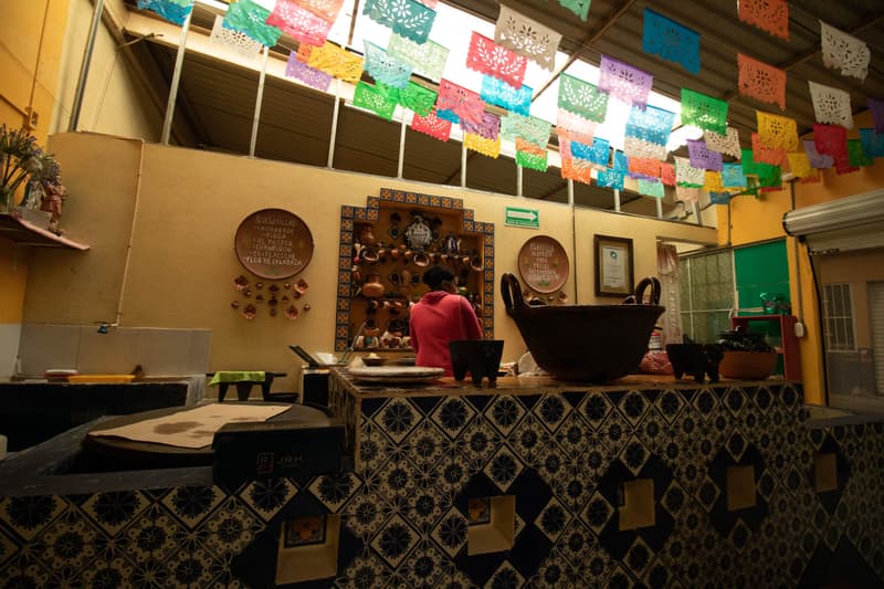 Cocina de un restaurante mexicano de colores vivos con banderines de papel picado