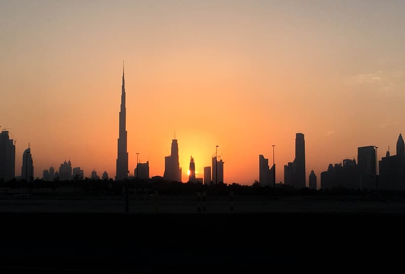 Dubai skyline in silhouette at sunset with the Burj Khalifa tower