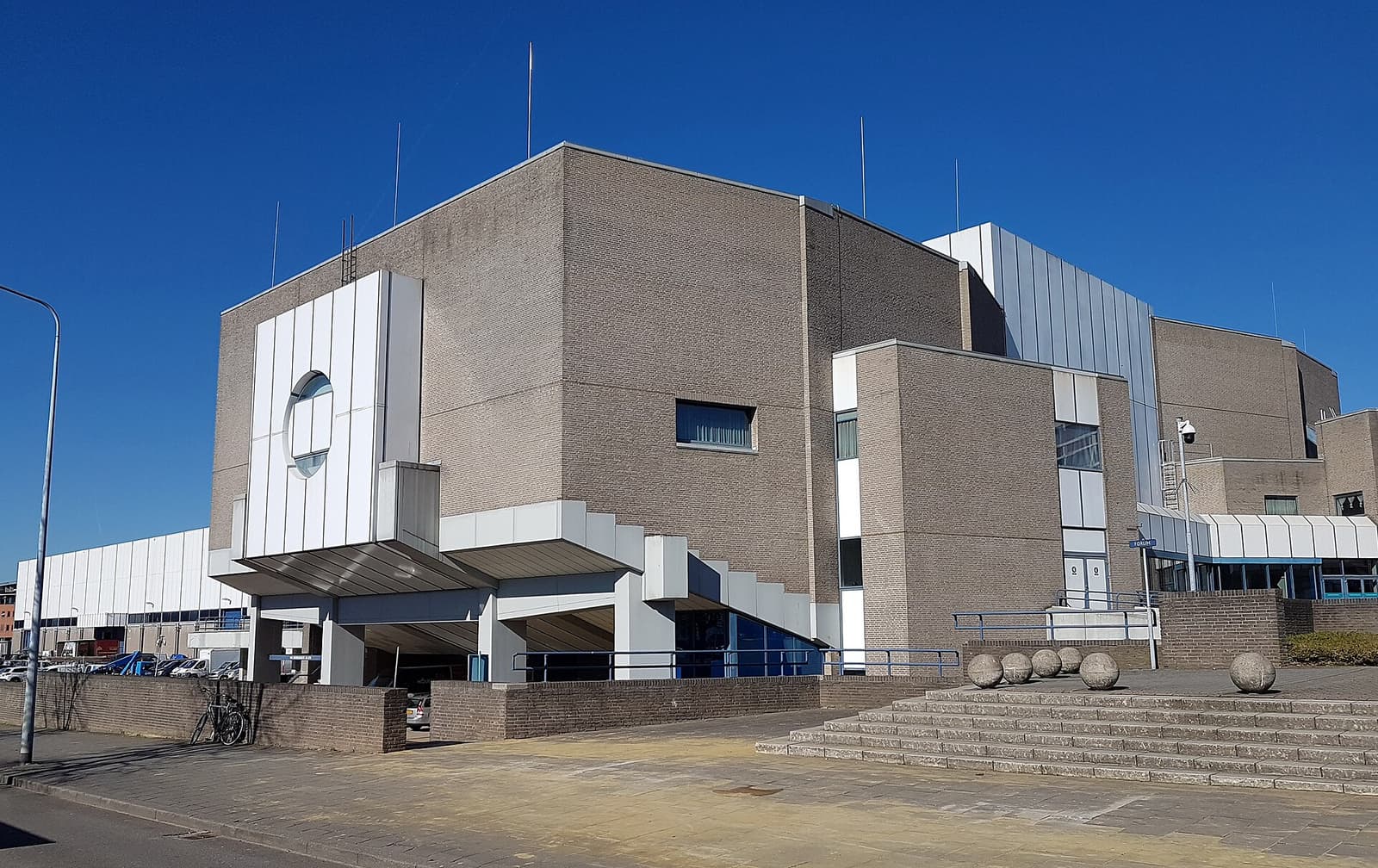 Aile des congrès du MECC de Maastricht, brique et panneaux blancs, sous un ciel bleu