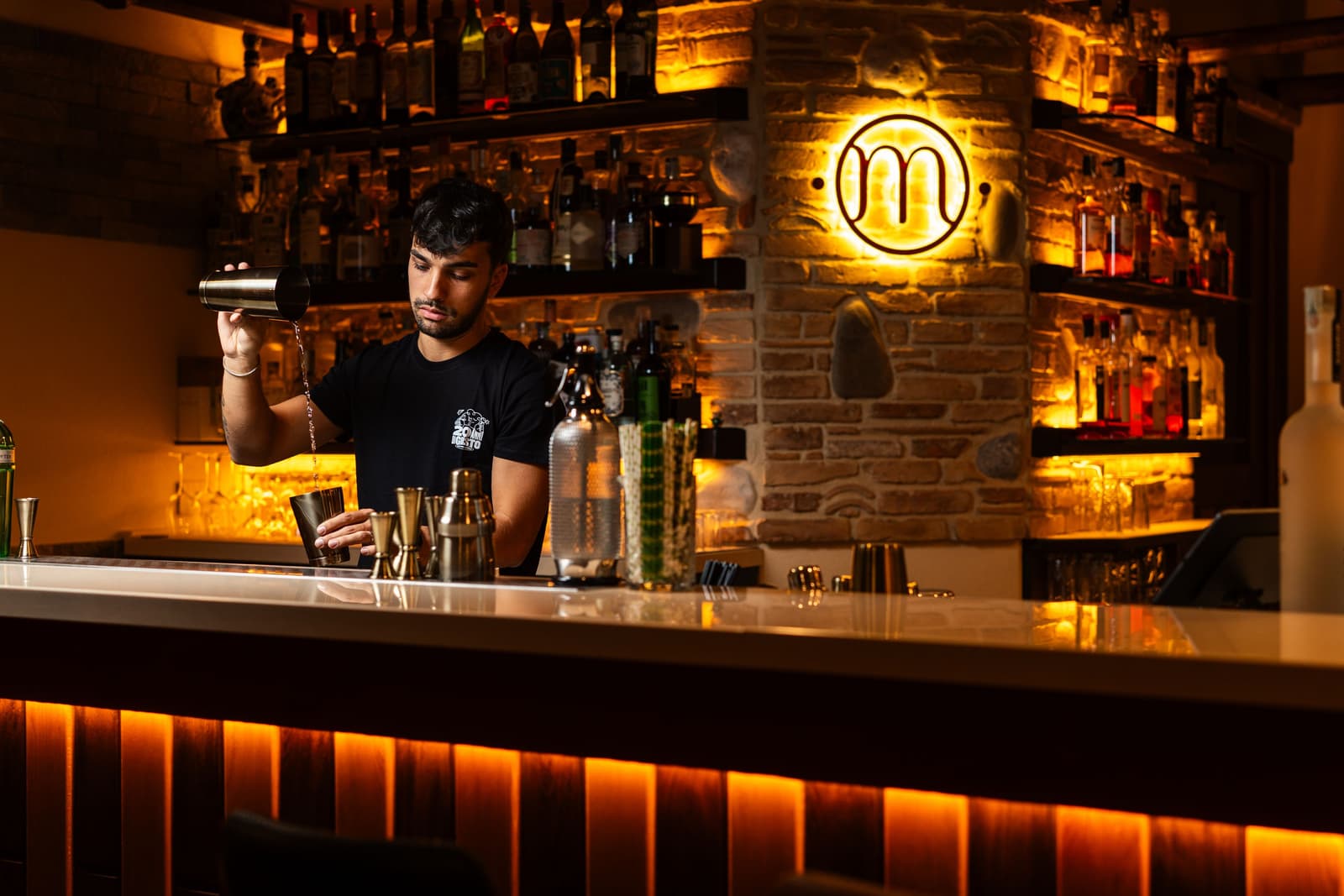 Barman die een cocktail mixt aan een stijlvolle bar