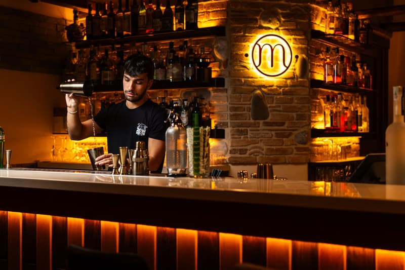 Barman préparant un cocktail à un comptoir élégant