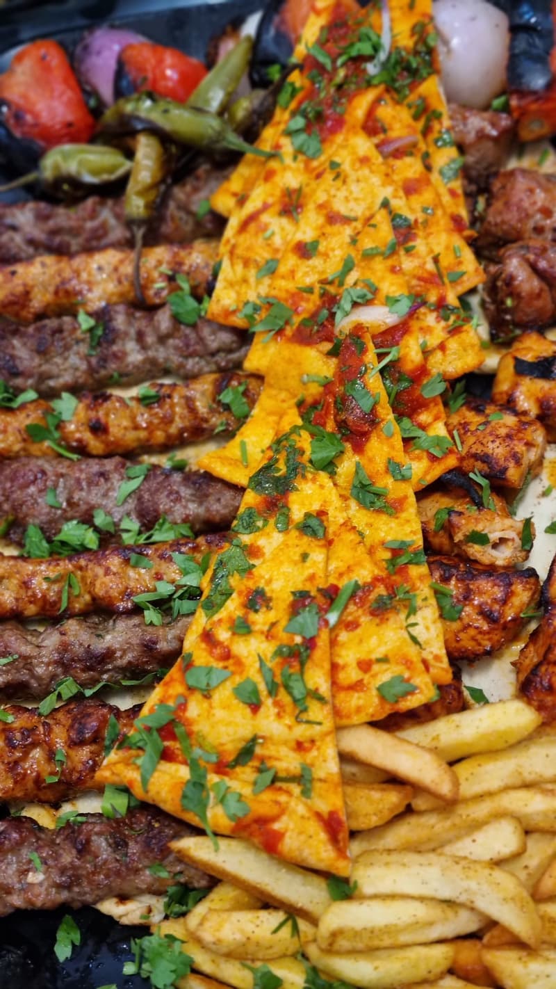 Persian-style grilled kebab sharing platter on a dark table