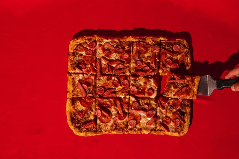 Vierkante Romeinse pizzapunten worden gesneden met een metalen spatel