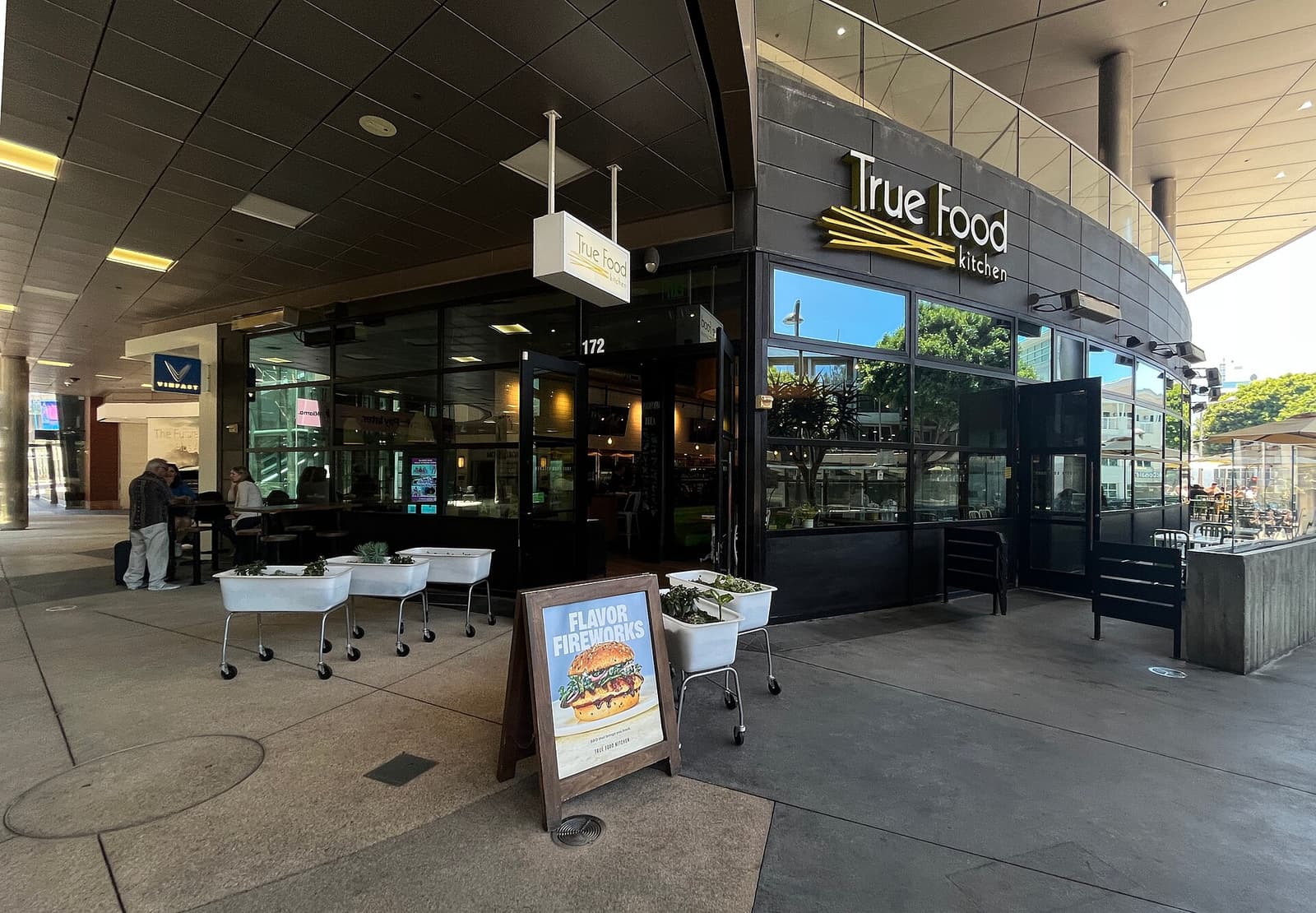 Buitenkant van een restaurant van True Food Kitchen in Santa Monica, met uithangbord en plantenbakken