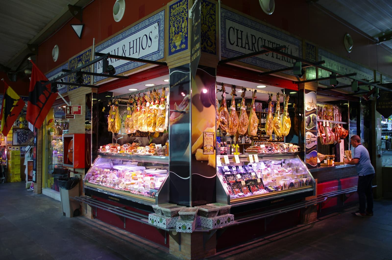 Prosciutti iberici appesi sopra una salumeria al mercato di Triana a Siviglia
