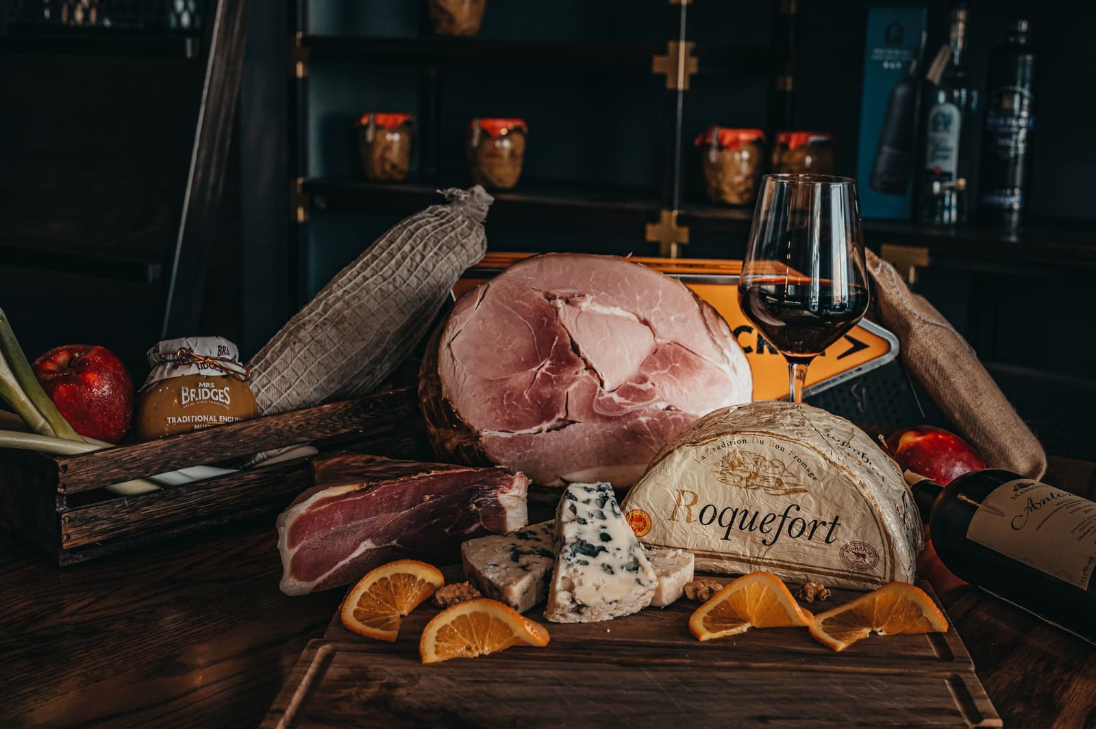 A glass of red wine with cheese and charcuterie on a wooden table